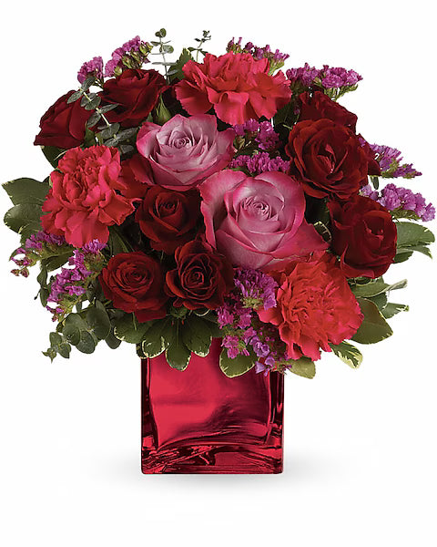 Classic bouquet of red and pink roses in bright red vase