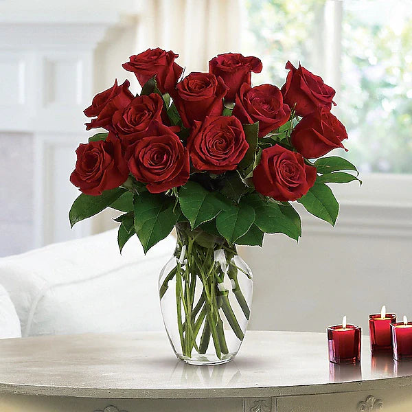 Fresh red roses by candlelight.